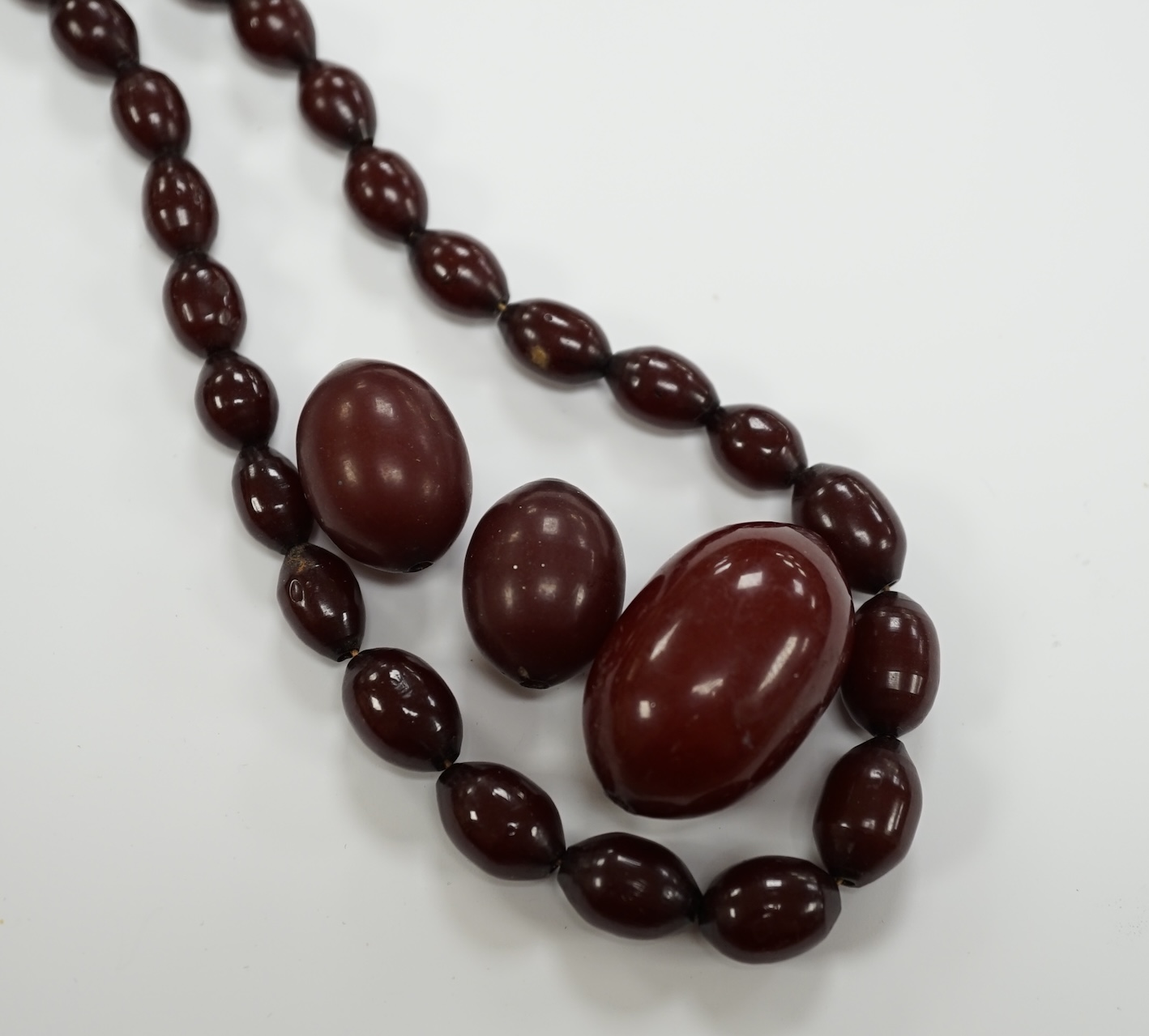 A single strand graduated simulated cherry amber bead necklace(a.f.), gross weight 50 grams.